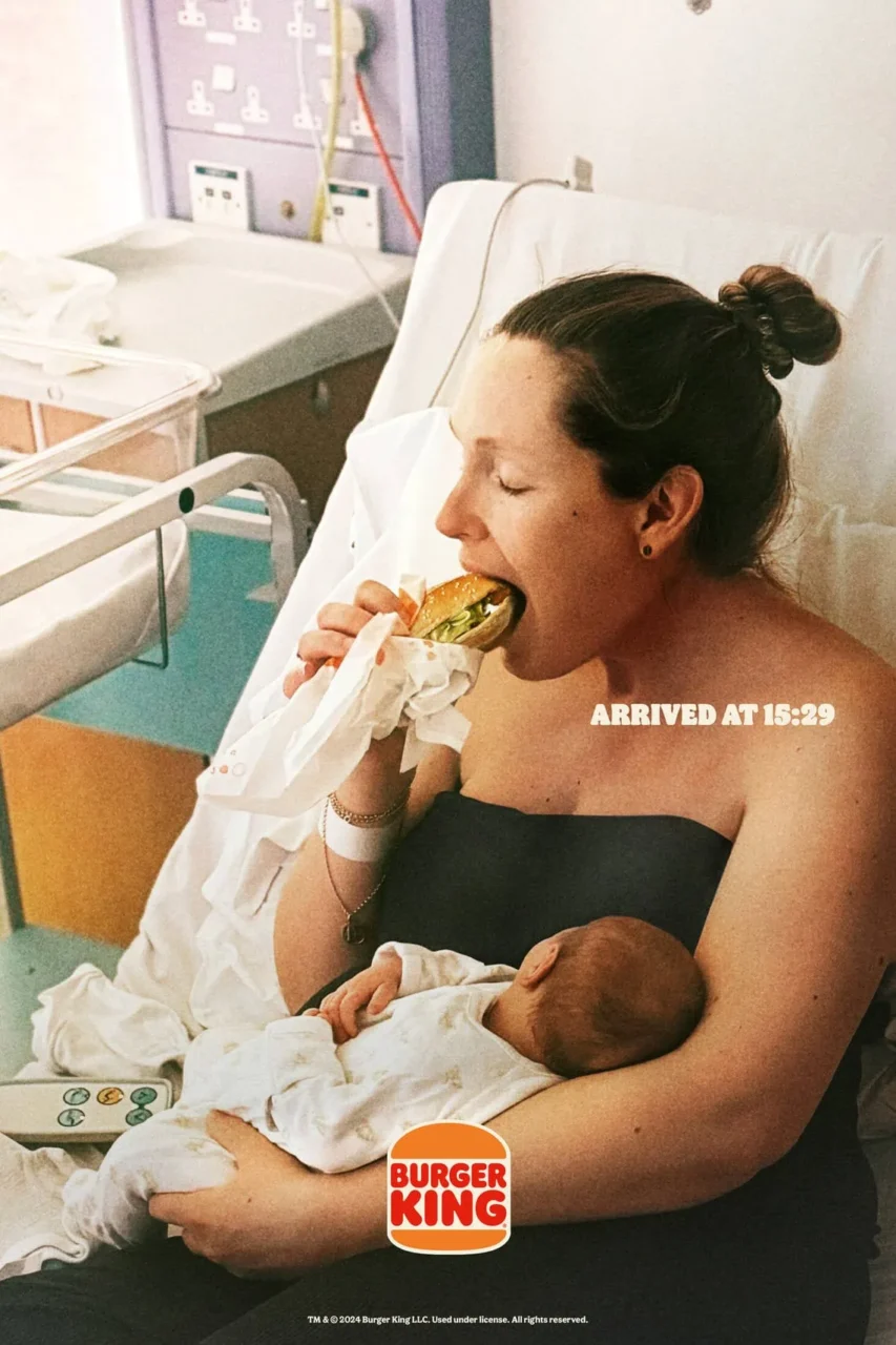 Mãe segurando bebê enquanto aproveita um Whopper na campanha "Bundles of Joy" do Burger King.