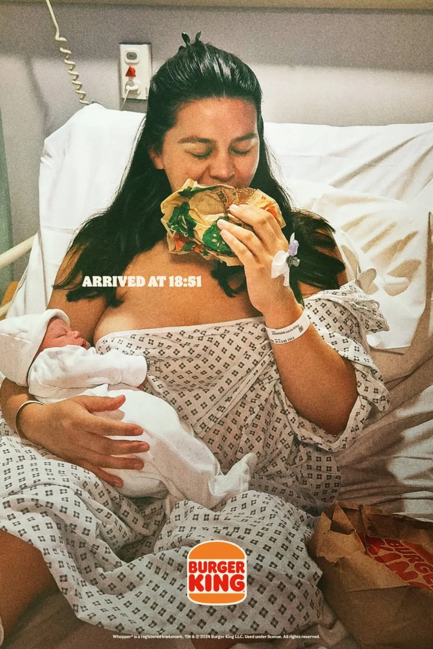 Mãe segurando bebê enquanto aproveita um Whopper na campanha "Bundles of Joy" do Burger King.