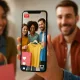 pessoas interagindo em compras ao vivo pelo celular, com ícones de curtidas e carrinho, transmitindo um clima moderno e conectado.